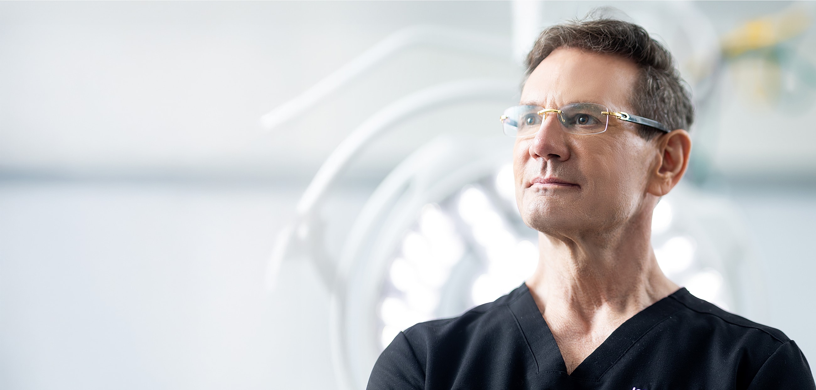 Surgeon in scrubs with focused expression.