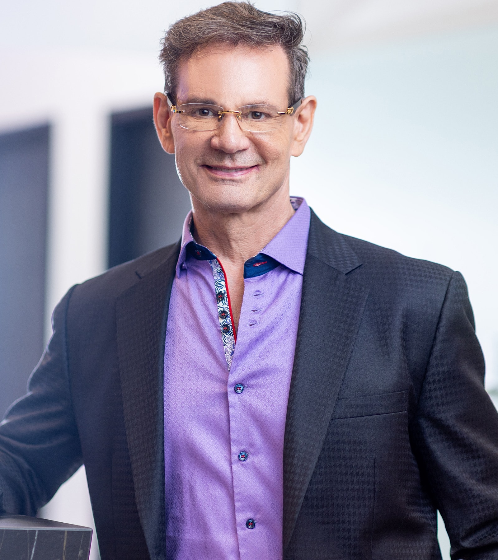Smiling man in a stylish purple shirt.