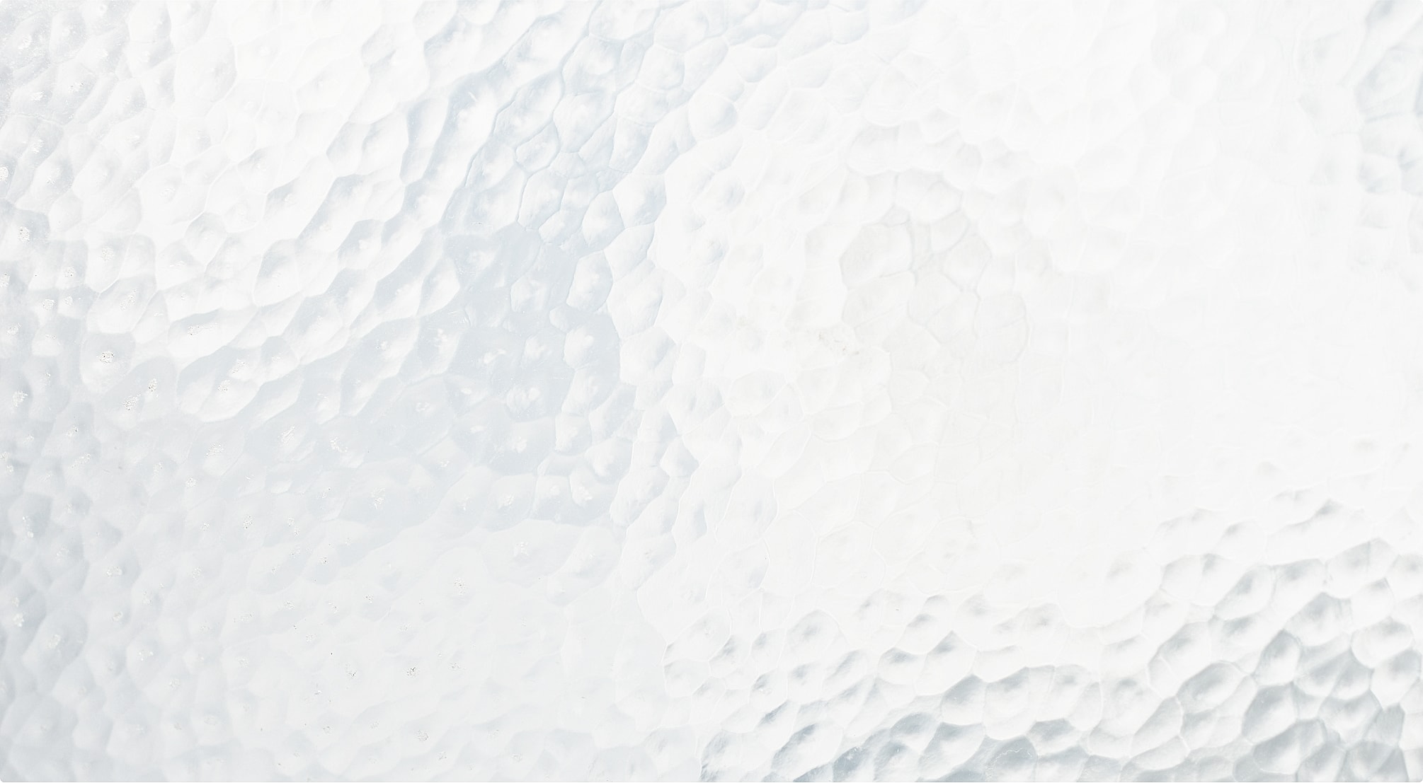 Textured frosted glass surface with soft reflections.