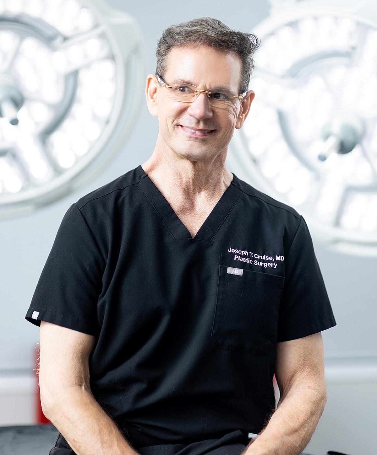 Man in stylish suit leaning against a wall.