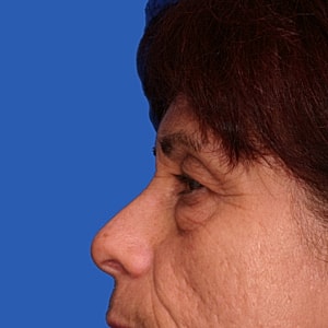 Profile view of a woman against blue background.