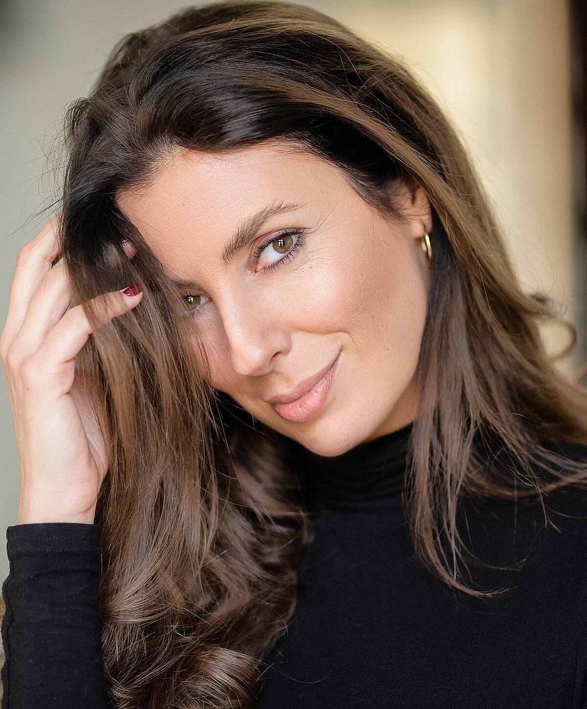 Woman with long hair in black turtleneck.