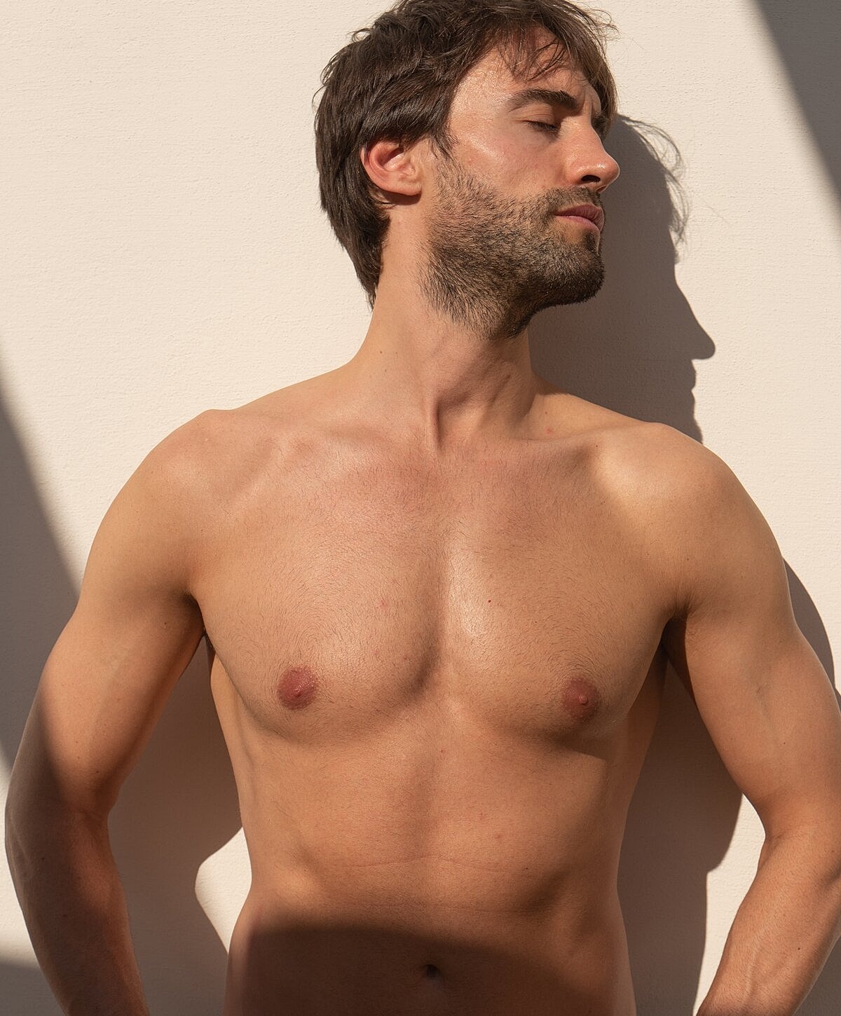 Shirtless man posing against a light background.