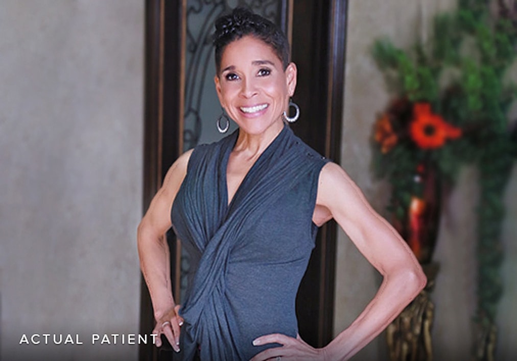 Smiling woman in stylish gray outfit.