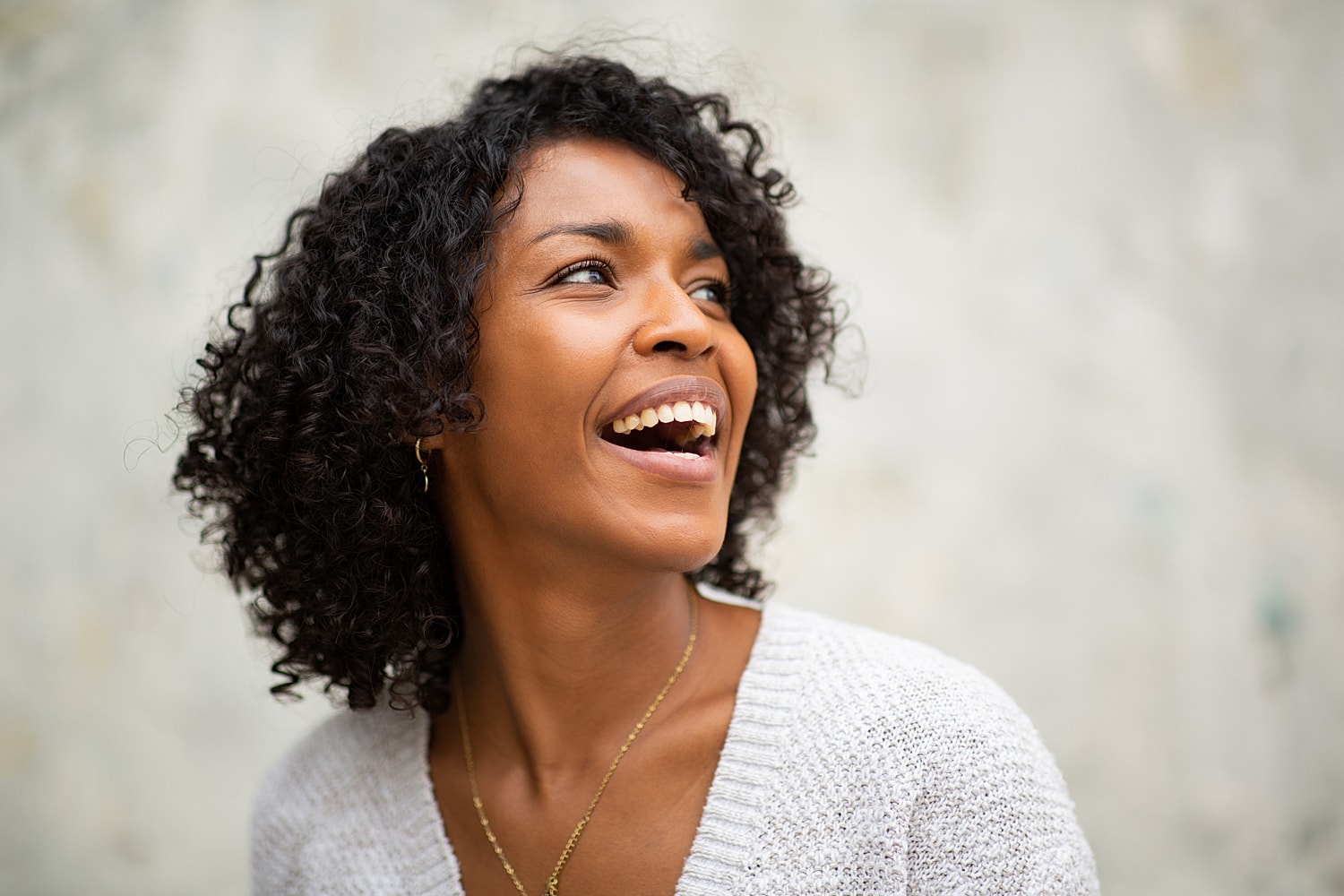 Orange County neck liposuction model with curly hair, enjoying life.