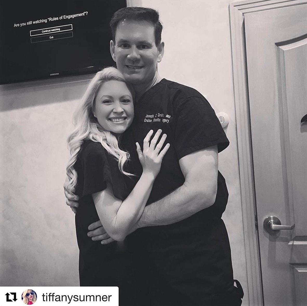 Smiling couple in medical attire embracing happily.
