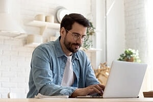 Man working on laptop in bright indoor space