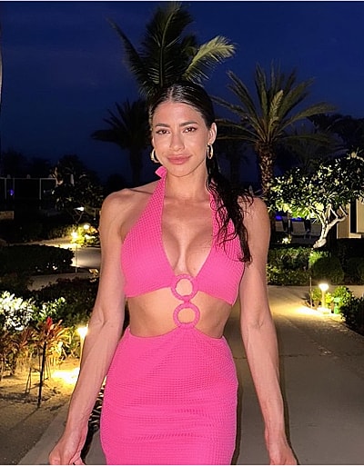 Woman in pink dress walking at night.