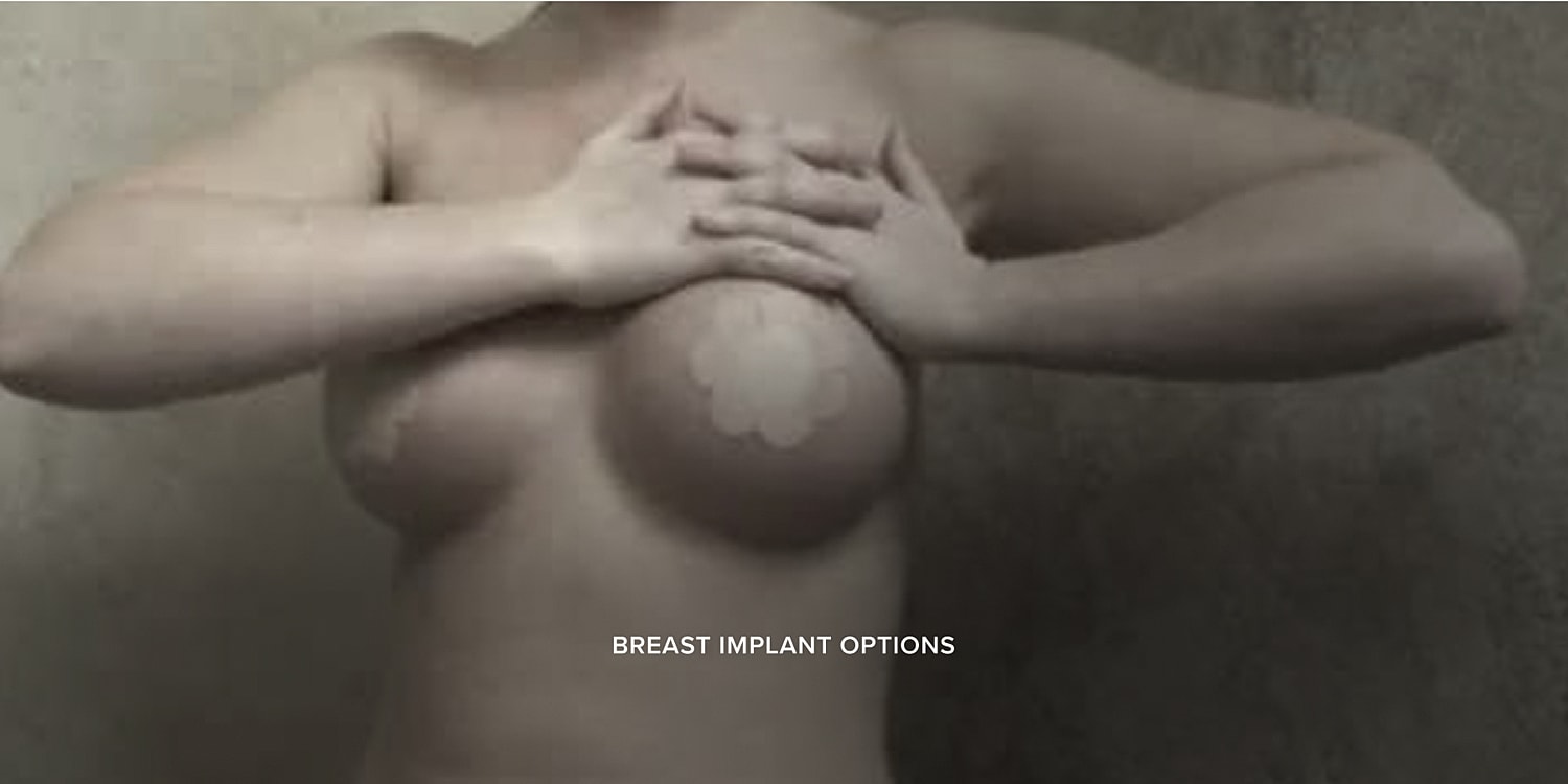 Nude model covering chest with hands.